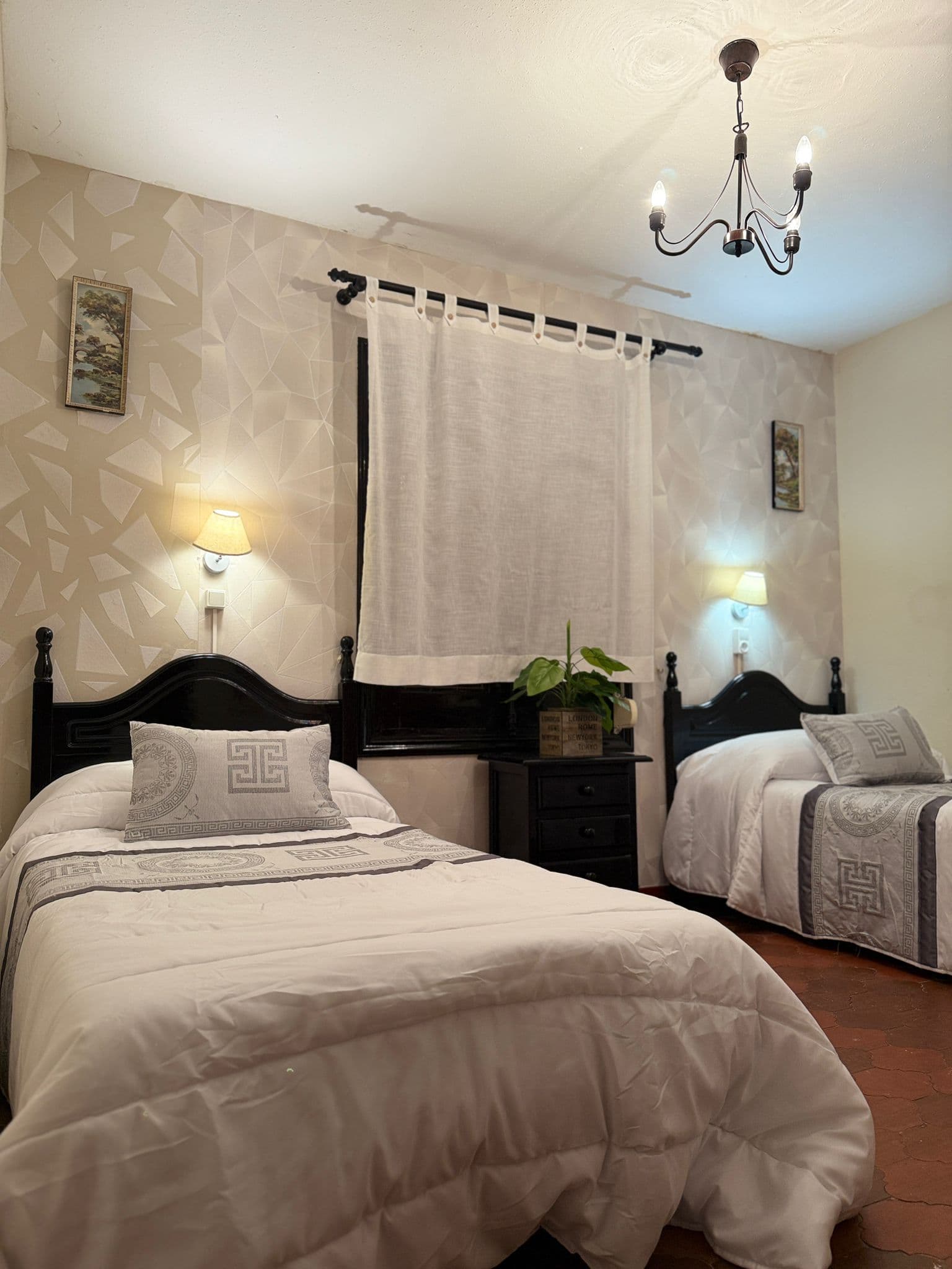 Habitación twin con dos camas individuales y decoración cálida.